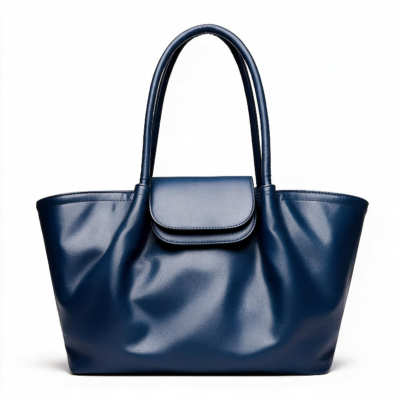 A navy blue faux leather tote bag with dual top handles and a matching flap closure, photographed against a clean white background.