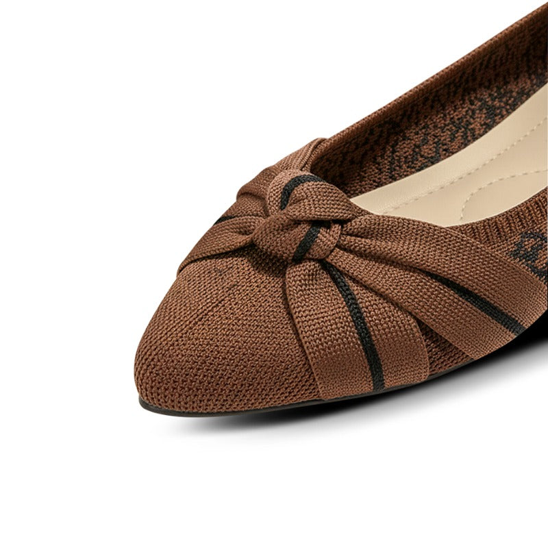 Brown flat shoe with a knotted design on a white background