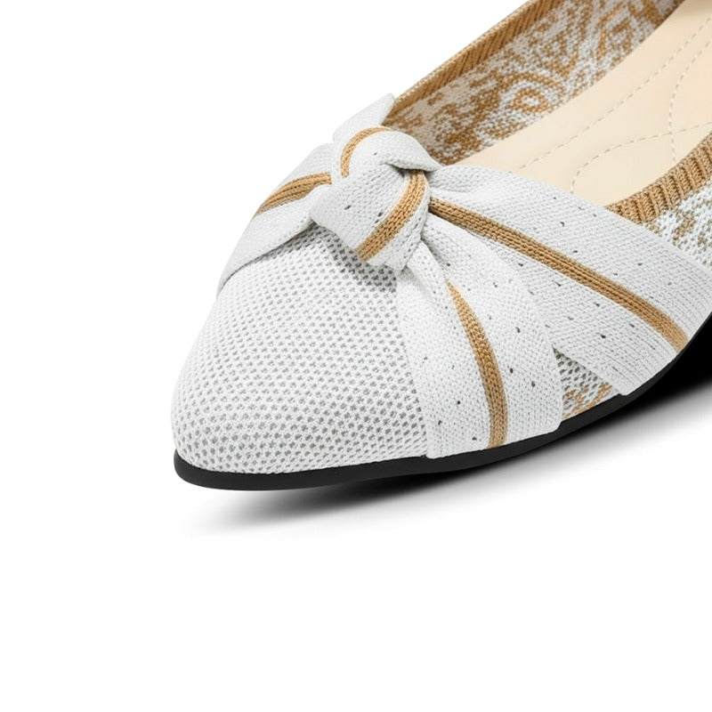 White flat shoe with a knot detail on a white background