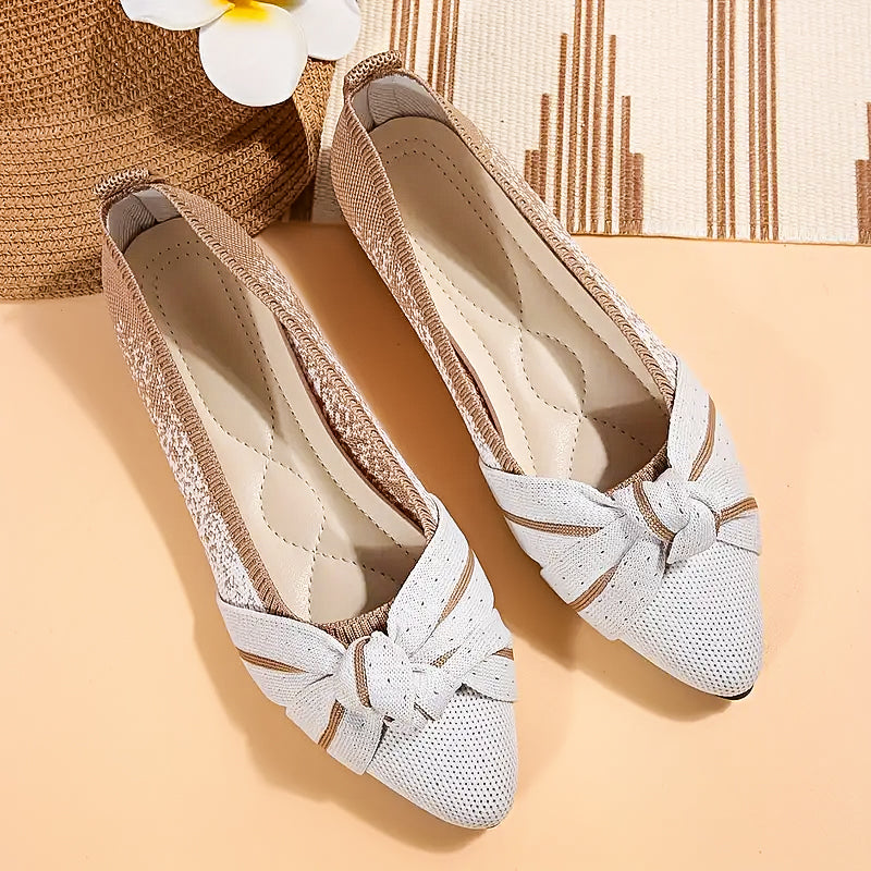White shoes with decorative bows on a beige surface